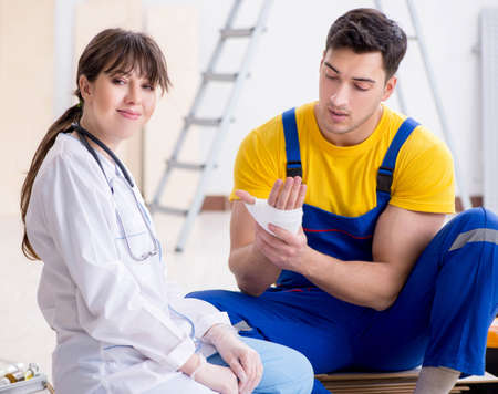 Injured worker being assisted by doctorの写真素材