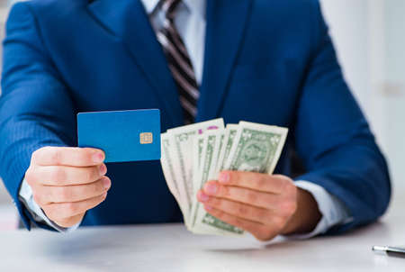 Businessman holding dollar money and credit cardの写真素材