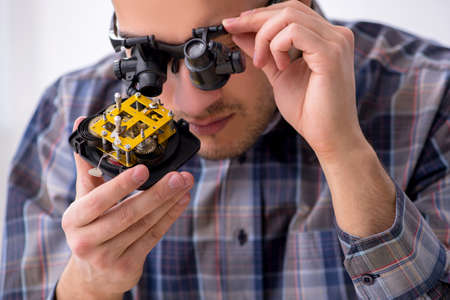 Young male watchmaker working in the workshop