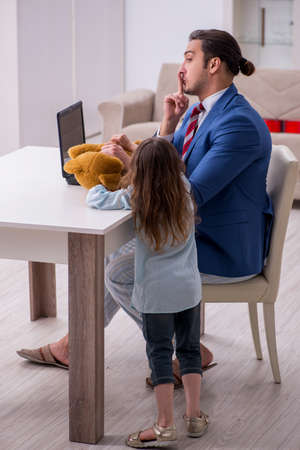 Girl bothering young father during working from house in pandemiの写真素材