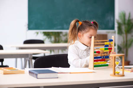 Small girl with abacus in the classroom