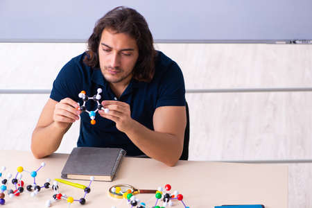 Young male scientist sitting in the classroom