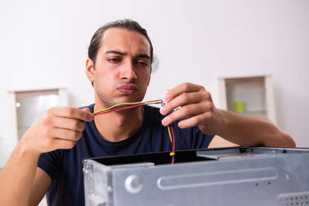 Young man repairing computer at home