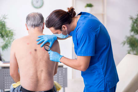 Old man visiting young male doctor dermatologist