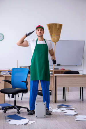 Young male contractor cleaning the officeの写真素材