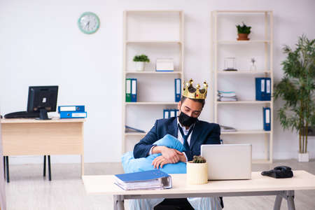 Young male employee during pandemic at workplaceの写真素材