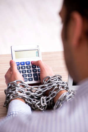 Chained male employee working in the officeの写真素材