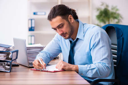 Young male businessman employee working in the officeの写真素材