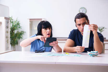 Female pensioner and her young son in budget planning concept