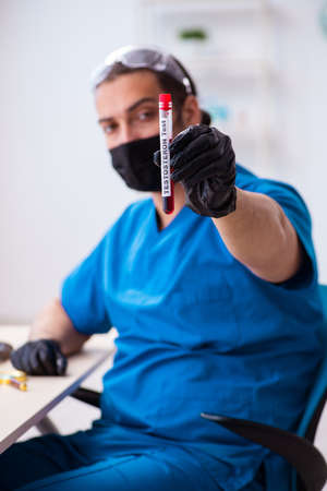 Young male biochemist testing blood samplesの写真素材
