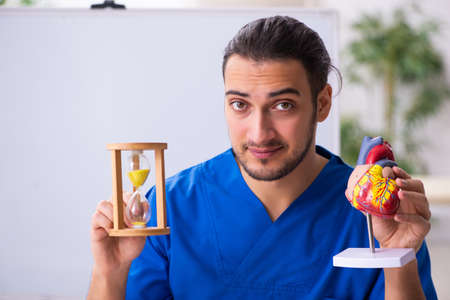 Young male doctor teacher cardiologist in front of whiteboardの写真素材
