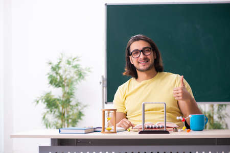 Young male student physicist preparing for exams in the classrooの写真素材