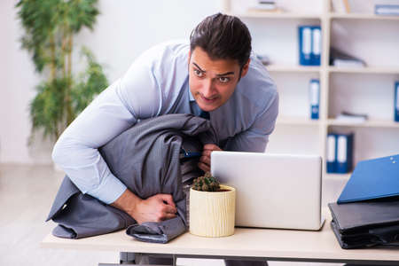 Young male employee unhappy with excessive workの写真素材