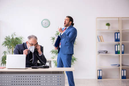 Two employees at workplace during pandemicの写真素材