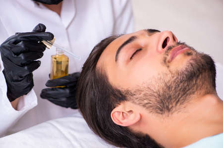 Young man visiting female beautician in hair transplantation conの写真素材