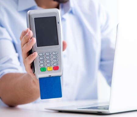 Man processing credit card transaction with POS terminal