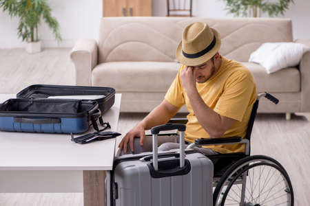 Young man in wheel-chair preparing for departure at homeの写真素材