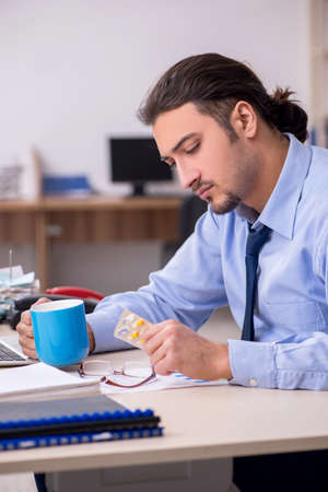 Sick male employee suffering at workplaceの写真素材