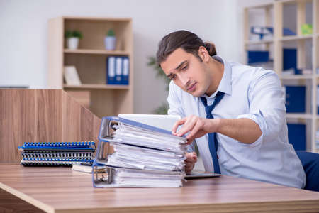 Young male employee unhappy with excessive workの写真素材