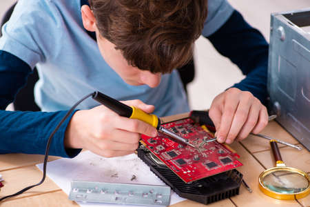 Boy reparing computers at workshop