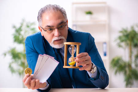 Old man earning money via Internet in time management concept