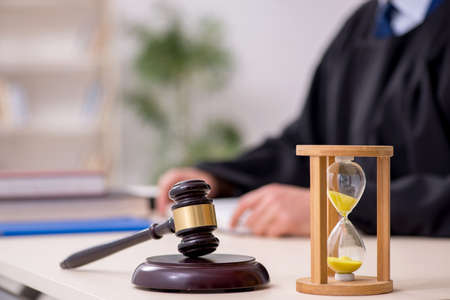 Young male judge in time management conceptの写真素材