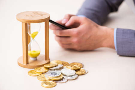 Young man earning money via Internet in time management conceptの写真素材