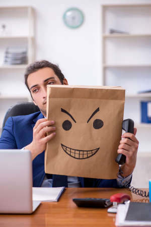 Young male employee with box instead of his headの写真素材