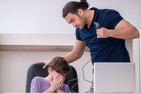 Young father and schoolboy playing computer games at homeの写真素材