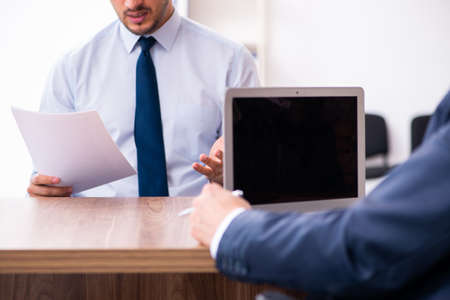 Young male candidate employee meeting with old recruiterの写真素材