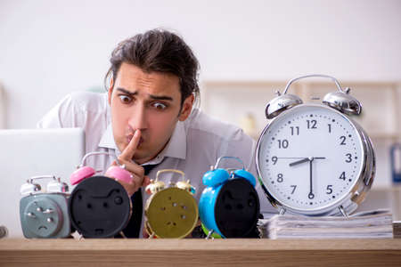 Young male employee afraid of missing deadline at workplaceの写真素材