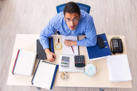 Young male bookkeper in budget planning conceptの写真素材