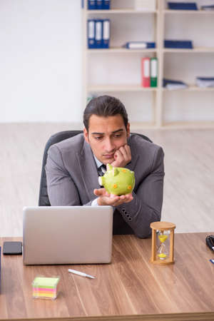 Young male employee in pension concept at workplaceの写真素材
