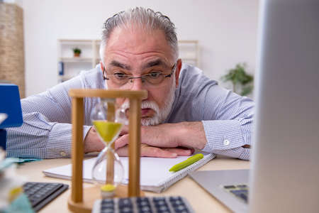 Old male accountant in budget planning concept in the officeの写真素材