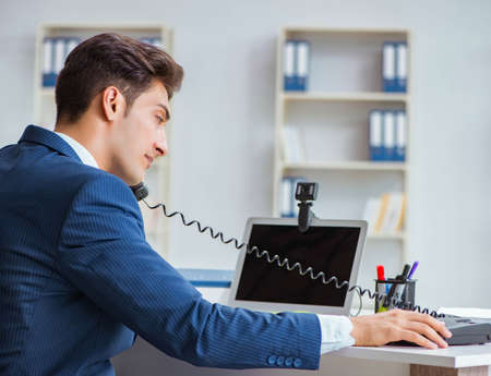 Young help desk operator working in officeの写真素材