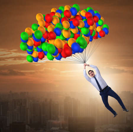 Businessman flying on balloons in challenge conceptの写真素材