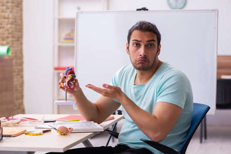 Young male student medic studying human anatomy at homeの写真素材