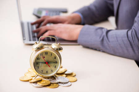 Young man earning money via Internet in time management conceptの写真素材