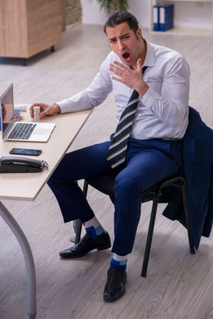 Sick male employee suffering at workplaceの写真素材