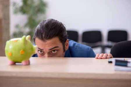 Young male employee in budget planning conceptの写真素材