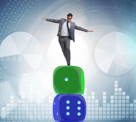 Businessman balancing on top of dice stack in uncertainty concepの写真素材