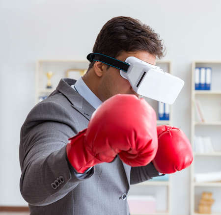 Man boxing in the office with virtual reality gogglesの写真素材