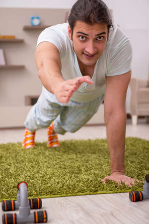 Young man doing sport exercises at home