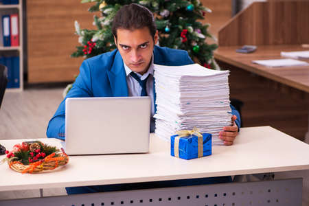 Young male employee working in the office at Chrismasの写真素材