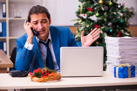 Young male employee working in the office at Chrismasの写真素材