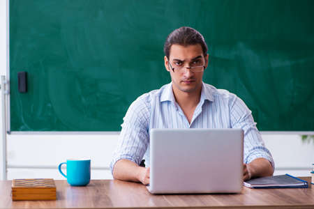 Young male teacher in tele-education concept in the classroomの写真素材