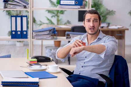 Hungry male employee waiting for food in time management conceptの写真素材