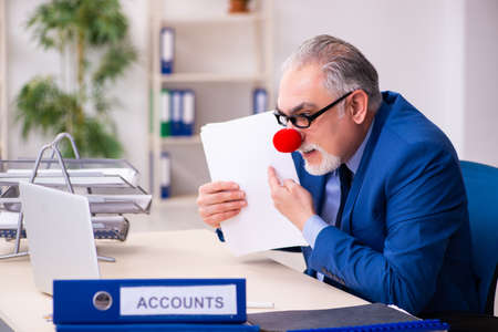 Old businessman clown working in the officeの写真素材