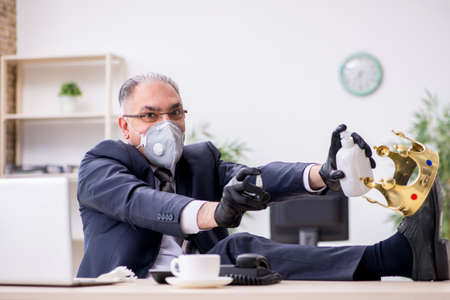 Old male boss employee working during pandemicの写真素材