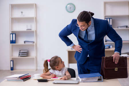 Young male employee and his little girl in the officeの写真素材
